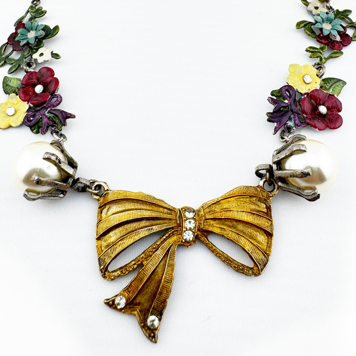 Perlenkette mit Schleifen und Blumen